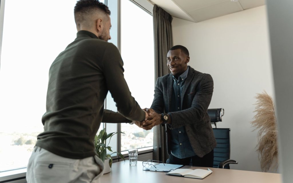 An employer and a placed candidate shaking hands after an offer is agreed